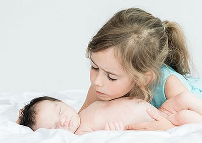 newborn photo of a little girl and her big sister
