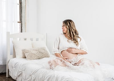 Pregnant woman in the studio on a bed. Owen Sound Family and Maternity Photographer.