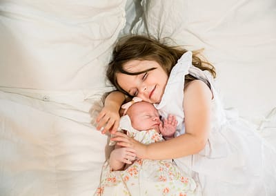 Little girl with her newborn sister