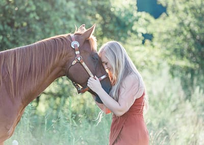 lady putting forehead to horse nose. horse portrait
